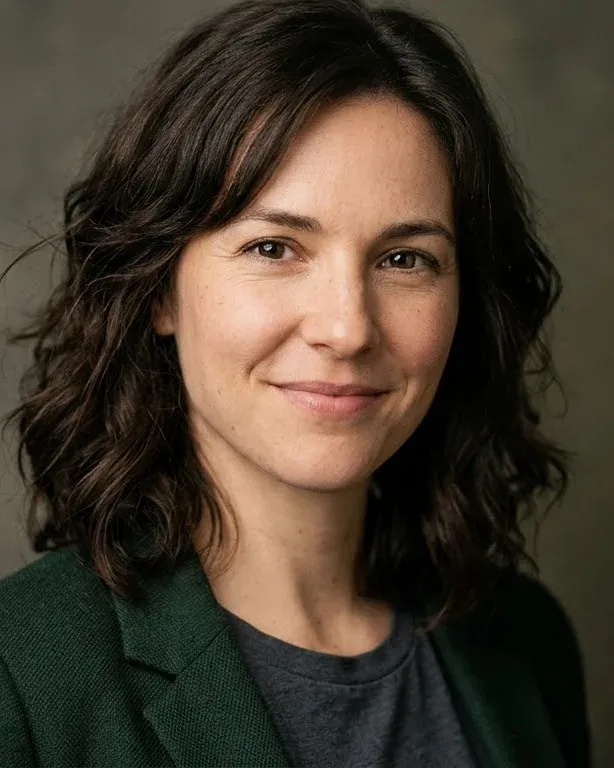 Head-and-shoulders portrait of a smiling woman with dark wavy hair